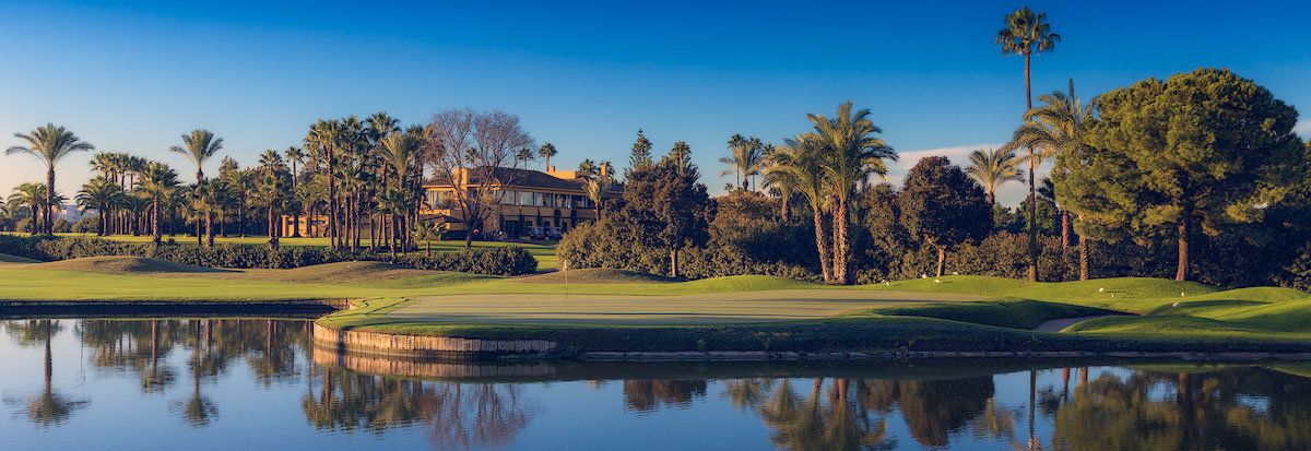 The 9th green at Real Club de Golf de Sevilla is surrounded by a lake