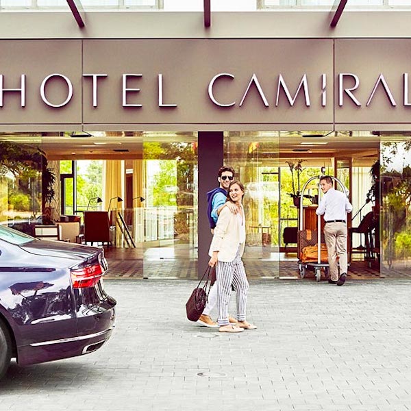 Couple strolling in front of Camiral Hotel