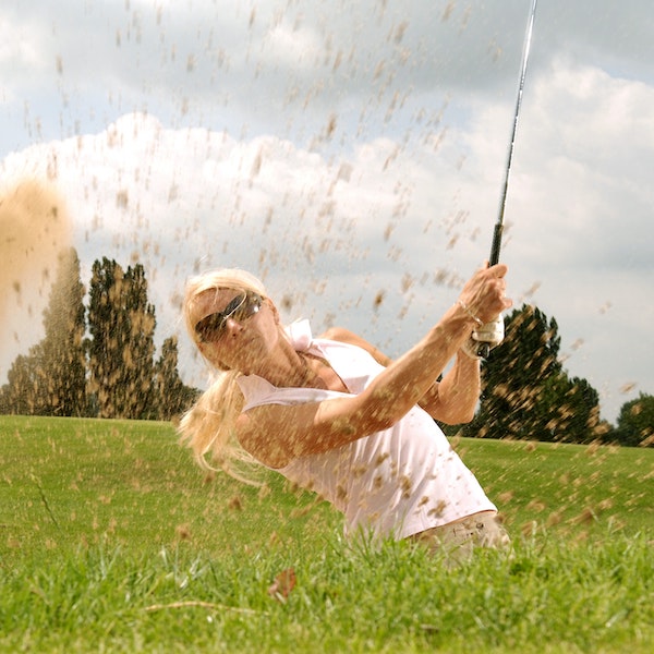 woman golfer in the sand