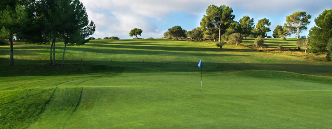 Rolling fairway leads to a large green on Maioris Golf