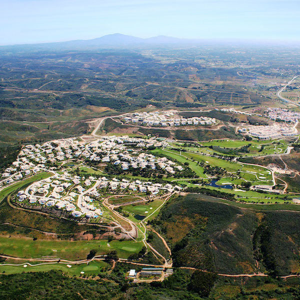 Aerial view of Santo Antonio Golf Resort including villas and golf course with mountains in the distance